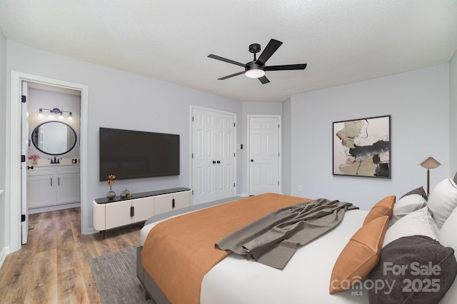 1640 English Knoll Dr, Matthews, NC 28105 - bedroom featuring wood finished floors, ensuite bath, a ceiling fan, a closet, and a textured ceiling