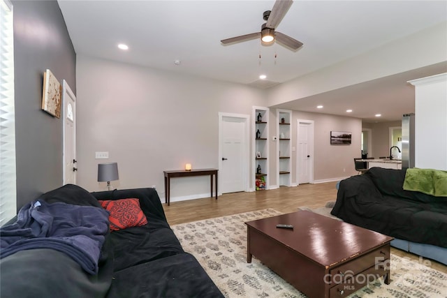 living room featuring a ceiling fan, light wood-style flooring, recessed lighting, and baseboards