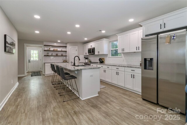 kitchen with stainless steel appliances, open shelves, a sink, white cabinetry, and recessed lighting