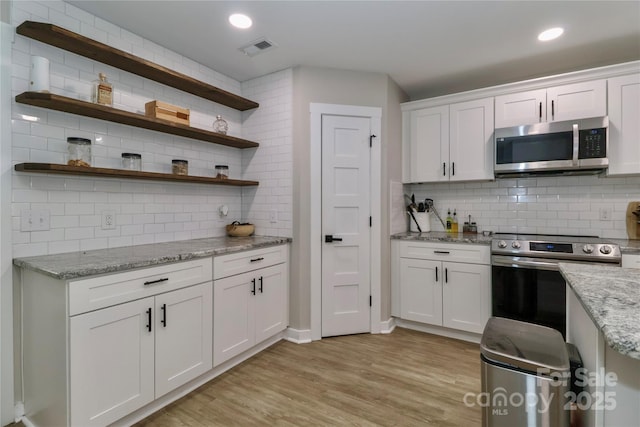 kitchen with stainless steel appliances, backsplash, open shelves, white cabinetry, and recessed lighting