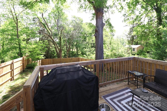deck with a grill and a fenced backyard