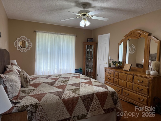 bedroom with a textured ceiling and a ceiling fan