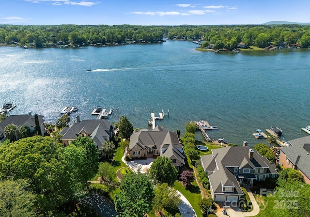 birds eye view of property with a water view, a residential view, and a wooded view