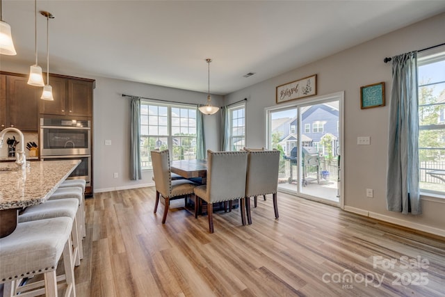 14925 Baldridge Dr, Huntersville, NC 28078 - dining room featuring light wood-type flooring, healthy amount of natural light, and baseboards
