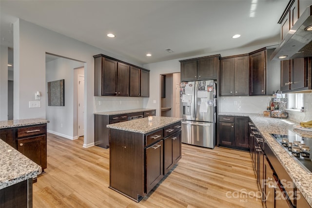 14925 Baldridge Dr, Huntersville, NC 28078 - kitchen featuring stainless steel refrigerator with ice dispenser, wall chimney range hood, dark brown cabinets, light wood finished floors, and tasteful backsplash