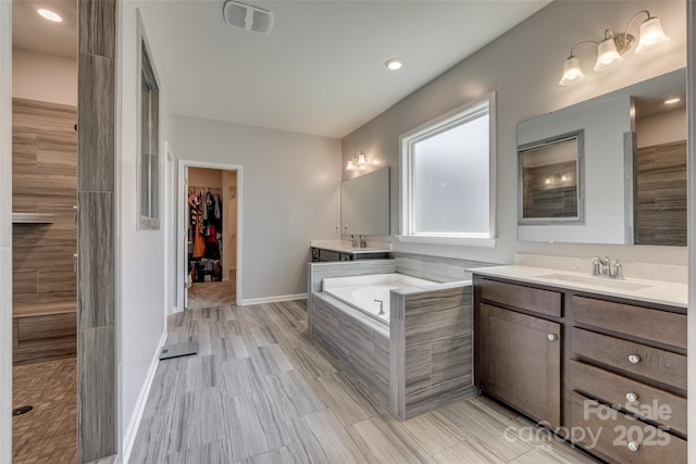 14925 Baldridge Dr, Huntersville, NC 28078 - bathroom featuring two vanities, a bath, and a walk in closet