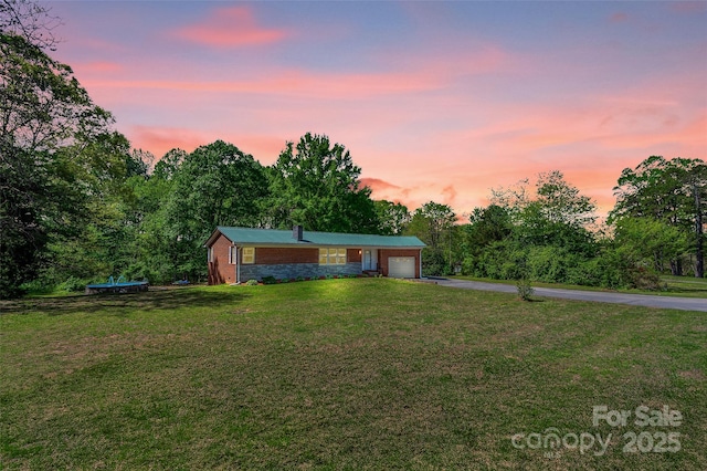 view of front of property with a garage, a front yard, and aphalt driveway