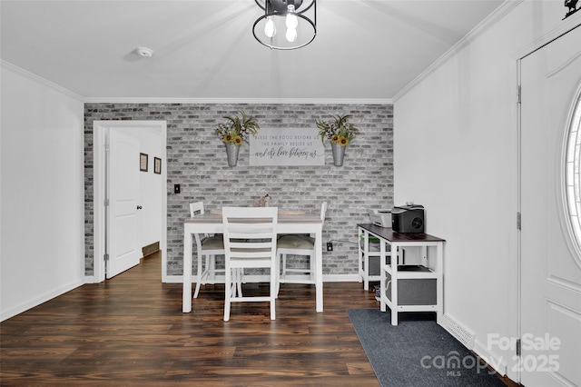 dining room featuring baseboards, wood finished floors, and crown molding