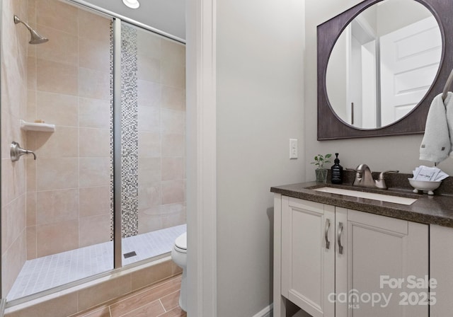 full bathroom featuring toilet, vanity, and a stall shower