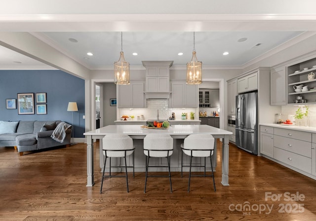 kitchen with a kitchen breakfast bar, stainless steel fridge with ice dispenser, light countertops, backsplash, and gray cabinetry