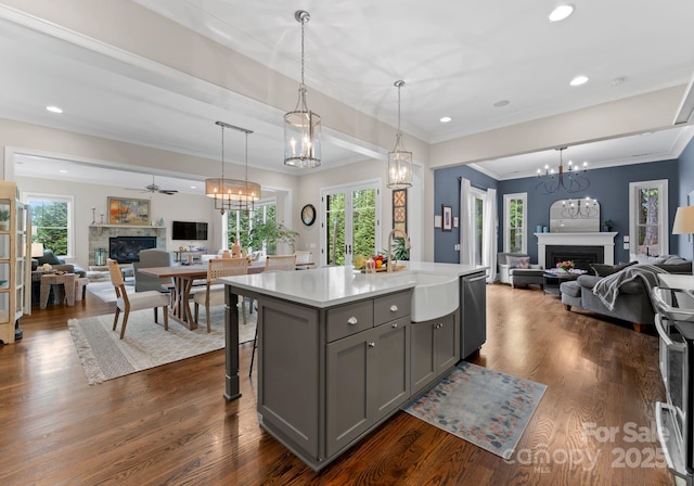kitchen with open floor plan, gray cabinetry, a sink, and a fireplace