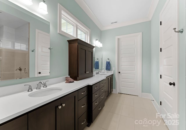 bathroom featuring tile patterned floors, visible vents, a sink, and a tile shower