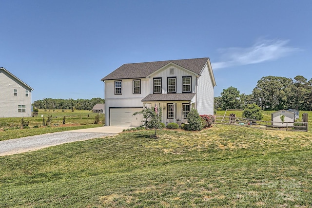 traditional-style home featuring a front lawn, fence, board and batten siding, an attached garage, and driveway