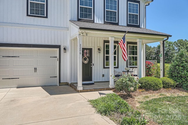 view of front of house with a porch, an attached garage, board and batten siding, and concrete driveway