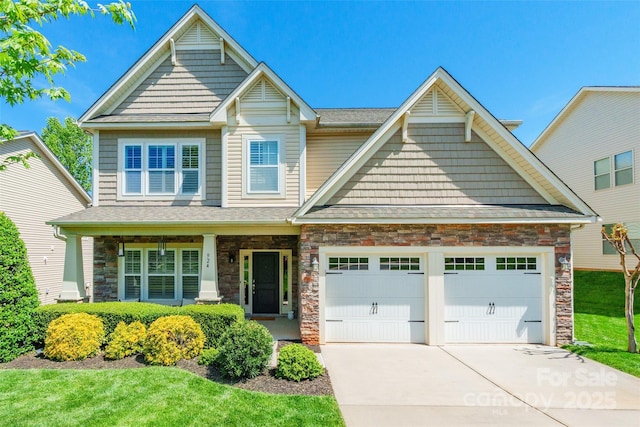 craftsman house with stone siding, covered porch, driveway, and an attached garage