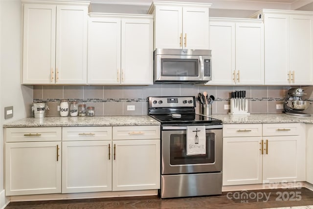 kitchen featuring white cabinetry, light stone countertops, stainless steel appliances, and decorative backsplash