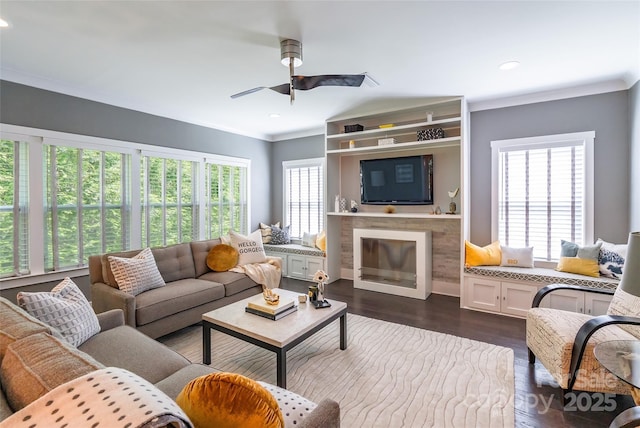 living room with ornamental molding, dark wood-style floors, a ceiling fan, and a wealth of natural light