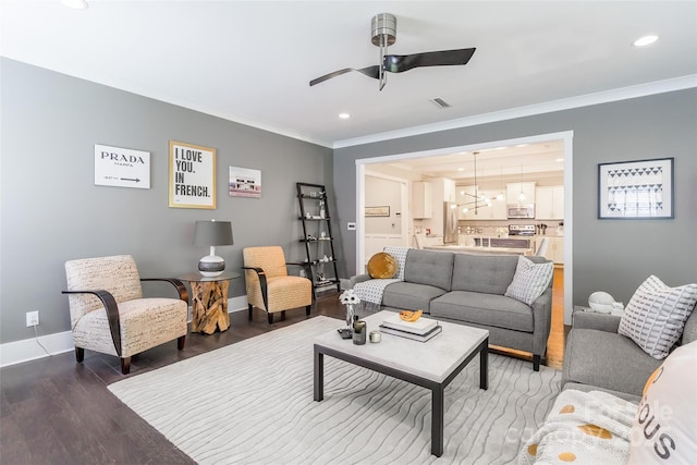 living area featuring recessed lighting, baseboards, ornamental molding, wood finished floors, and ceiling fan with notable chandelier