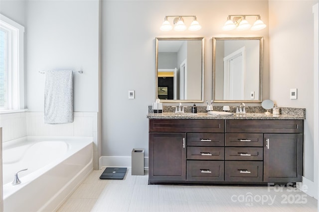 bathroom featuring a garden tub, double vanity, and a sink