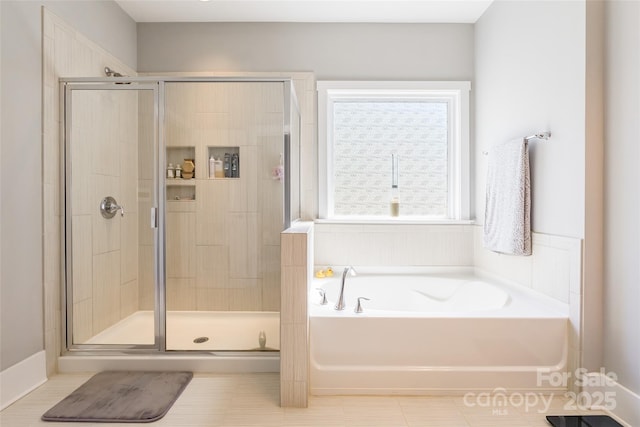 bathroom with a garden tub, a shower stall, and tile patterned floors