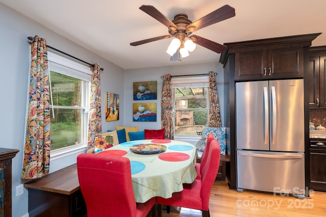 dining space with healthy amount of natural light, light wood-type flooring, and ceiling fan