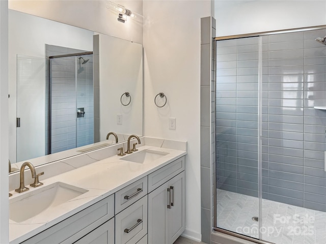 bathroom with a stall shower, double vanity, and a sink