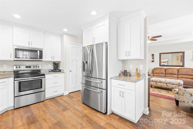 kitchen with open floor plan, recessed lighting, appliances with stainless steel finishes, and light wood-type flooring