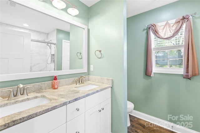 full bath featuring a shower stall, toilet, a sink, and baseboards