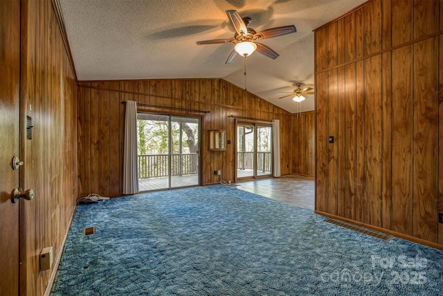 605 Hennessee St, Morganton, NC 28655 - unfurnished room featuring wood walls, ceiling fan, lofted ceiling, carpet floors, and a textured ceiling