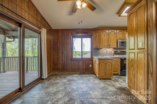 605 Hennessee St, Morganton, NC 28655 - kitchen with electric range oven, stainless steel microwave, a sink, wood walls, and ceiling fan