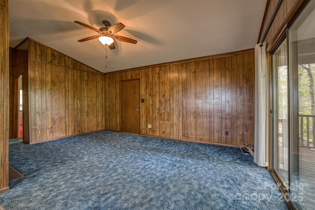 605 Hennessee St, Morganton, NC 28655 - empty room featuring a ceiling fan, wooden walls, vaulted ceiling, carpet, and a textured ceiling