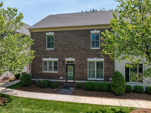 colonial house featuring brick siding