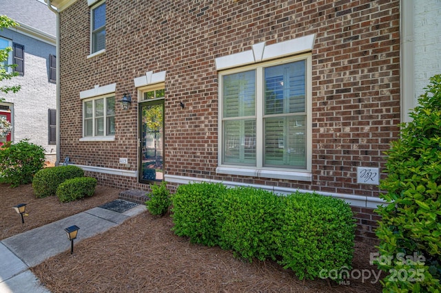 doorway to property featuring brick siding