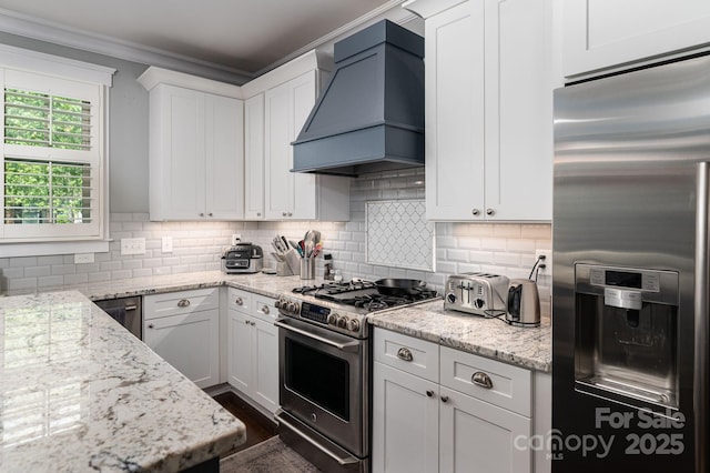 kitchen with premium range hood, backsplash, appliances with stainless steel finishes, and white cabinetry