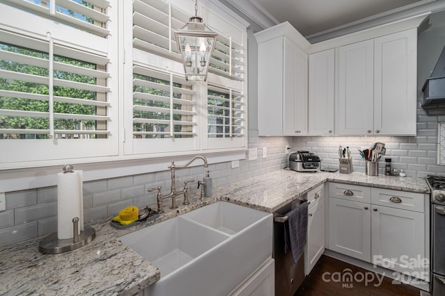 kitchen with dishwasher, a sink, backsplash, and white cabinetry