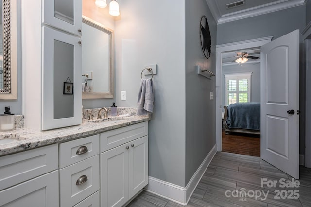 full bath featuring visible vents, a ceiling fan, vanity, ornamental molding, and ensuite bath