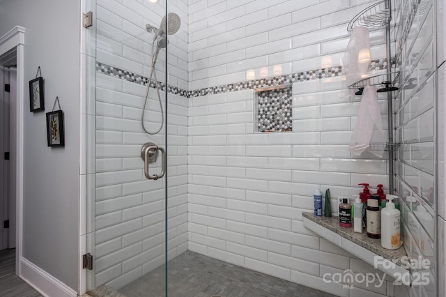 full bathroom featuring a shower stall and baseboards