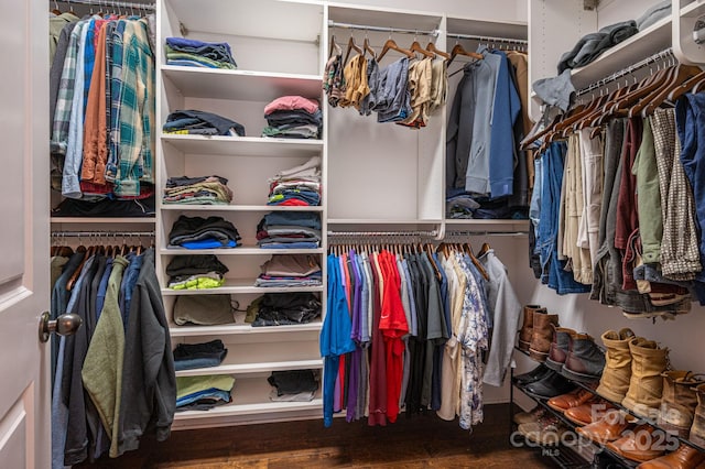 walk in closet with wood finished floors