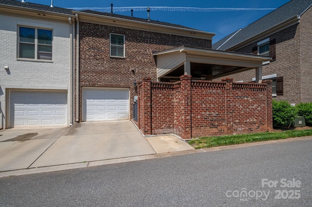 view of front facade featuring brick siding, driveway, and a garage