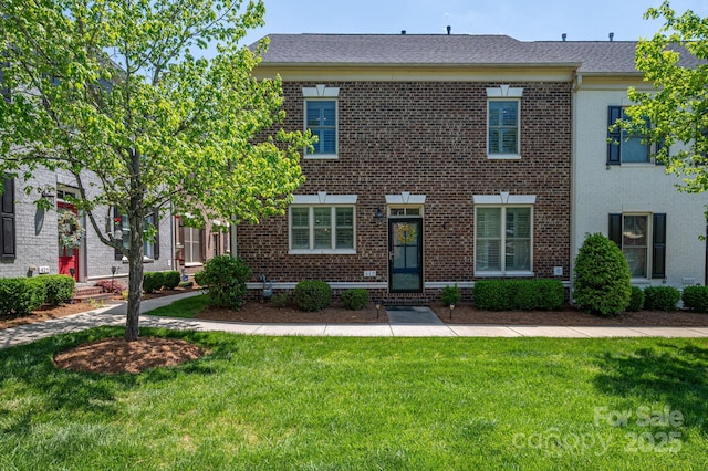 multi unit property with a front lawn and brick siding