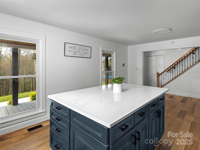 30 Gap Hill Dr, Fletcher, NC 28732 - kitchen featuring blue cabinetry, a kitchen island, wood finished floors, and light stone countertops