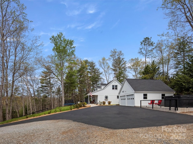 30 Gap Hill Dr, Fletcher, NC 28732 - view of side of property with board and batten siding, a trampoline, a detached garage, and driveway