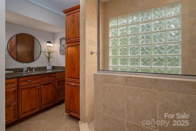 bathroom featuring vanity, tile patterned floors, tiled shower, and ornamental molding
