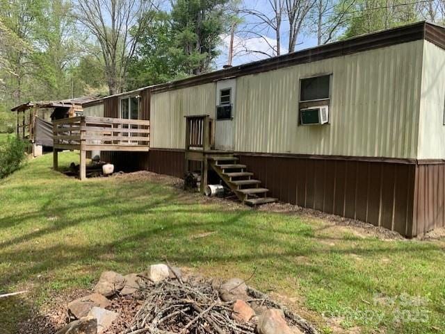 rear view of house with a wooden deck, a yard, and cooling unit