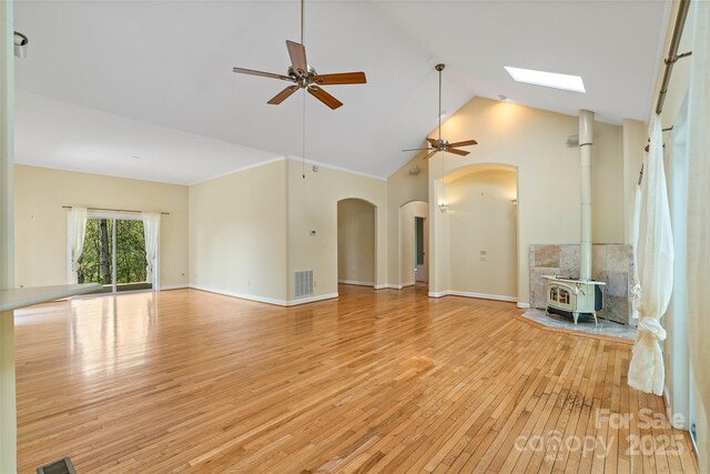 80 Ivy Cove Rd, Fairview, NC 28730 - unfurnished living room with light wood-type flooring, ceiling fan, visible vents, and a wood stove