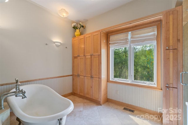 80 Ivy Cove Rd, Fairview, NC 28730 - full bathroom featuring tile patterned floors, wainscoting, baseboards, visible vents, and a freestanding tub