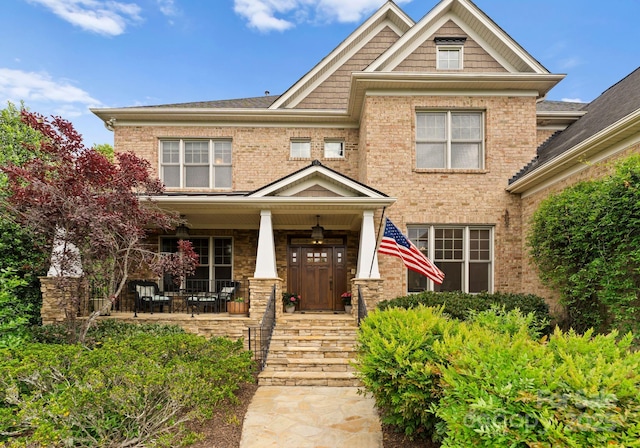 view of front of home with covered porch and brick siding
