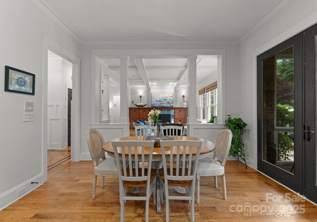 dining room featuring light wood-style floors, ornamental molding, and baseboards