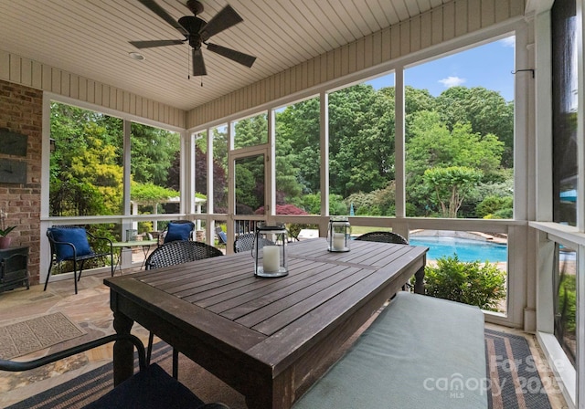 sunroom / solarium with a ceiling fan and outdoor dining space