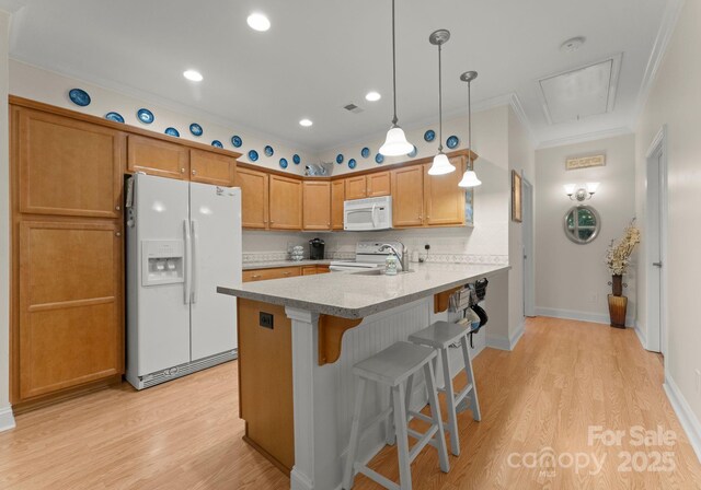 kitchen featuring a kitchen breakfast bar, a peninsula, light wood finished floors, ornamental molding, and white appliances